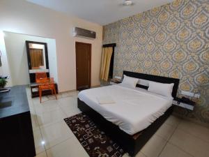 a bedroom with a bed and a wall at Goroomgo Blue Bell Bhubaneswar in Bhubaneshwar