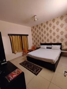 a bedroom with a bed and a television in it at Goroomgo Blue Bell Bhubaneswar in Bhubaneshwar