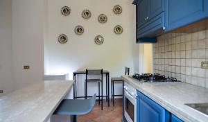 a kitchen with blue cabinets and tables and chairs at Palazzo del Miglio in Belvedere Marittimo