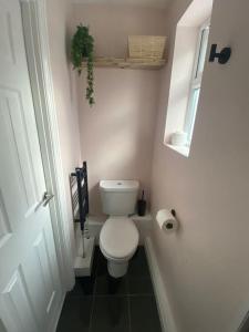a small bathroom with a toilet and a window at Cabin de la Paix in Hadleigh