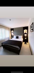 a bedroom with a large bed and two lamps at Koc Hotel in Karasu