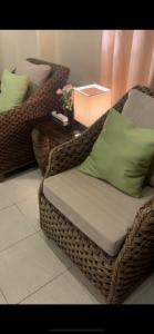 wiklinowe krzesło z zieloną poduszką i stołem w obiekcie Kleos Villa Baguio City w mieście Tuding