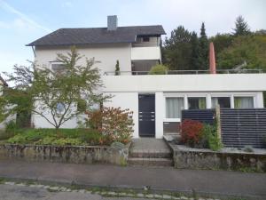 uma casa branca com uma porta preta em Ferienwohnung am Wildpark HDH em Heidenheim an der Brenz
