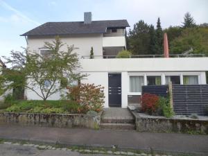 una casa bianca con una porta nera di Ferienwohnung am Wildpark HDH a Heidenheim an der Brenz