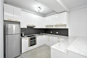 a white kitchen with white appliances and marble counters at 2 Bedrooms Cozy Apartment In Center Of Yerevan in Yerevan