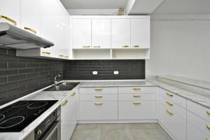 una cucina bianca con armadi bianchi e lavandino di 2 Bedrooms Cozy Apartment In Center Of Yerevan a Yerevan