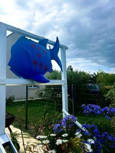 Ein Schild mit einem Hai im Garten. in der Unterkunft La Villa KEROMER in Étel