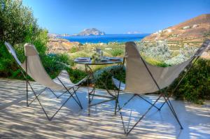 2 sillas y una mesa con vistas al océano en Amorgos Villa Handras / Main villa, en Amorgós