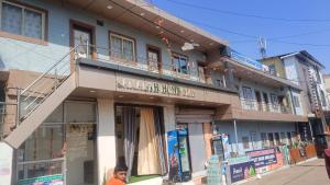 a woman is standing in front of a building at Samarth home`stay in Pachmarhī