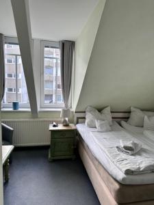 a bedroom with two beds and two windows at Hotel Villa Weststrand in Borkum