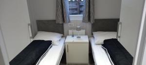 a room with two beds and a desk and a window at Gloednieuw luxe chalet met infraroodsauna in Hoenderloo