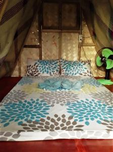 a bed in a tent with a bedspread on it at SHALOM CAMP in El Nido