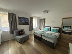 1 dormitorio con 1 cama y 1 silla en Boutique Hotel Pohorje, en Maribor