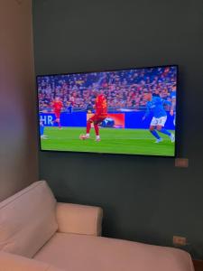 TV de pantalla plana colgada en la pared en La casa di Memè en Bianco
