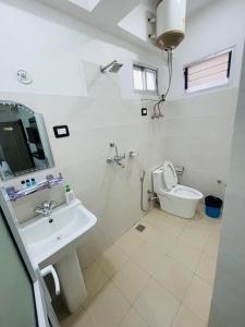 Baño blanco con lavabo y aseo en Hotel Janakpur Inn, en Janakpur