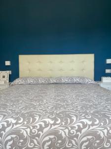 1 dormitorio con 1 cama grande y pared azul en La casa di Memè en Bianco