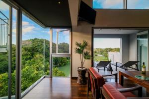a living room with a table and chairs and a large window at RIVERSIDE TERRACE OKINAWA KADENA in Kadena