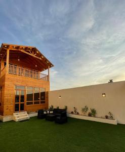 a building with a patio with green grass at اكواخ وشاليهات لوزان الريفية in Dahaban