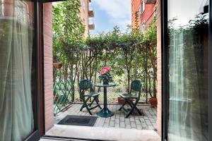 un patio con 2 sillas y una mesa con un jarrón de flores en Little canal 8, en Venecia