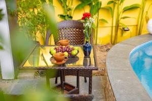 a table with a bowl of fruit on a chair at Oha Hoi An Villa in Hoi An