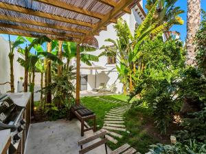 un patio con un banco bajo una pérgola de madera en Mediterranean tropical house, en El Campello