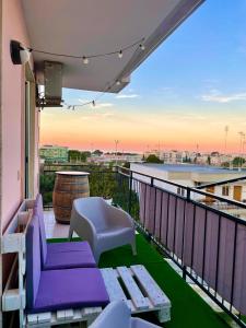balcone con mobili viola e vista sulla città di Wanderlust house a Bari