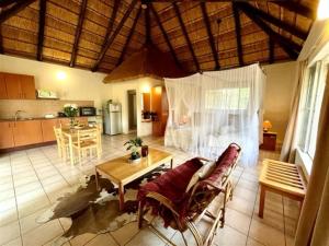uma sala de estar com uma mesa e uma cozinha em Tamanini Timbavati Lodge em Hoedspruit