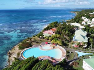 - une vue aérienne sur un complexe avec une piscine et l'océan dans l'établissement Appartement vue mer Anse des rochers, à Saint-François