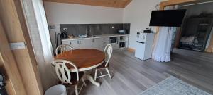 a kitchen with a wooden table and chairs and a kitchen with a television at Meander Country Cabins & Vans in Meander