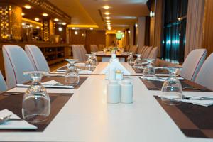 a long table in a restaurant with chairs and bottles at Tulip Plaza By LPC Hotels & Resorts in Hafr Al Baten