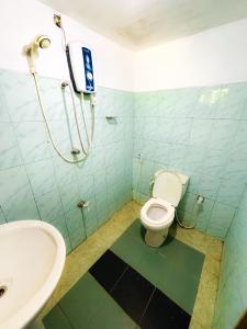 a bathroom with a toilet and a sink at Knuckles Home Stay in Rattota
