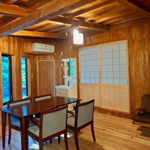 een eetkamer met een houten tafel en stoelen bij 旅館 竹屋 Takeya in Yufu