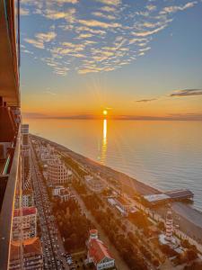 vista de uma cidade com o pôr do sol sobre a água em Batumi VIP hotel em Batumi