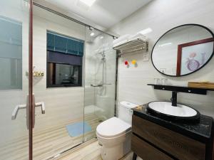 ein Bad mit einer Dusche, einem WC und einem Waschbecken in der Unterkunft 千岛湖月下民宿 in Liyang