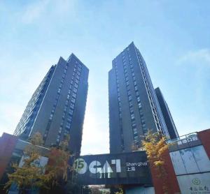 twee hoge wolkenkrabbers in een stad met bomen bij ZHome-Deplex luxury apartment-Near The Bund in Shanghai