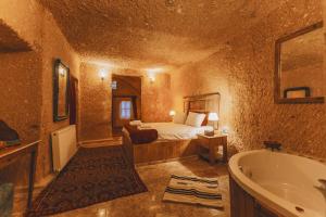 Un dormitorio con una cama y una bañera en una habitación. en Zula Cave House, en Ürgüp 119 fotos más