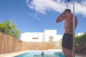 un homme debout dans une piscine parlant sur un téléphone portable dans l'établissement Casa Marlene, à Rodalquilar