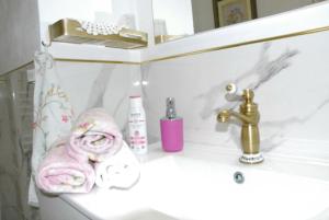 um lavatório de casa de banho com uma toalha rosa e uma torneira em ViLLETTA CLAUDETTA em Laveno-Mombello