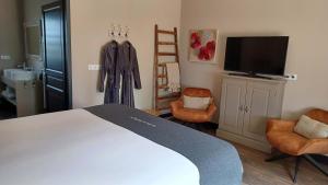 クー・エ・ビガロックにあるLa Douce Dordogneのベッドルーム1室(ベッド1台、椅子2脚、テレビ付)