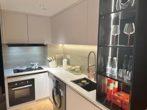 uma cozinha com armários brancos e um forno com placa de fogão em ZHome-Count luxury apartment em Xangai