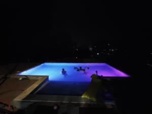 two people swimming in a pool at night at Rez-de-villa climatisé, jacuzzi et piscine in La Roquette-sur-Siagne