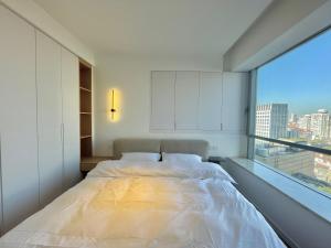 ein Schlafzimmer mit einem großen Bett und einem großen Fenster in der Unterkunft ZHome-Count luxury apartment in Shanghai