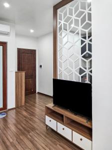 una sala de estar con TV de pantalla plana en un armario en CHLOE'S SERVICED APARTMENT - VINHOMES MARINA, en Xóm Niêm