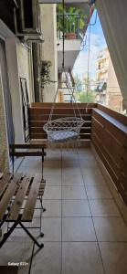 a porch with a swing and a bench on a balcony at Athens Near Acropolis in Athens