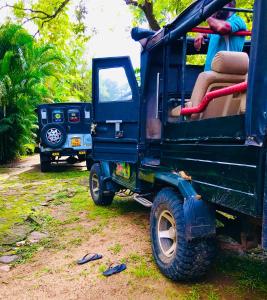 ein grüner Jeep, der neben einem Jeep parkt und die Tür geöffnet ist in der Unterkunft Randiya Holiday Resort in Minneriya