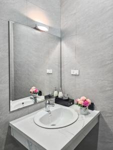 baño con lavabo y espejo grande en CHLOE'S SERVICED APARTMENT - VINHOMES MARINA, en Xóm Niêm