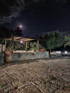 a gazebo with potted plants on it at night at La corte del nonno by Itriahomes in Ceglie Messapica