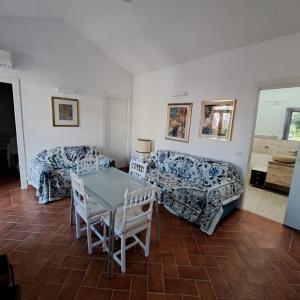 Una sala de estar con dos sofás y una mesa. en Villa Maria, en La Maddalena