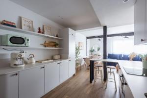 a kitchen with white cabinets and a table and chairs at Exclusive cozy Atocha apartment in Madrid