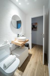 a white bathroom with a sink and a mirror at Exclusive cozy Atocha apartment in Madrid